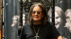 Ozzy Osbourne tahta benzeyen bir sandalyede oturuyor arkasında death metal müzisyenlerinin görselleri görünüyor. 