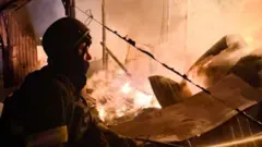 Пожежник сидить на фоні пожежі у Фастові