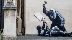 Граффити на стене суда: судья в парике избивает молотком лежащего на земле протестующего с плакатом в одной руке. Мимо проходит судья в парике и манти, говоря по телефону, с папкой в руке