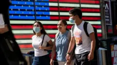 People wear masks around Times Square, as cases of the infectious coronavirus Delta variant continue to rise in New York City, New York, U.S., July 23, 2021.