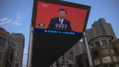Chinese President Xi Jinping is seen on a big screen showing the Chinese state television CCTV evening news as the city gets ready for the upcoming centenary of the Communist Party of China on June 30, 2021 in Beijing, China.