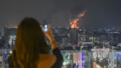 Lübnanlı bir kadın, bir bombanın yarattığı dumanın fotoğrafını çekiyor.