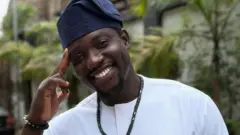 Man in white smiling for the camera