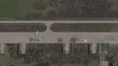 A satellite image showing damaged Russian planes on a runway. Three damaged jets are circled in the photo, which is imposed over the BBC Verify colours and accompanied by the BBC Verify logo in the top left corner. 