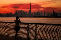 A woman takes a picture of the Dubai skyline with Burj Khalifa, the world's largest building, as viewed from Creek Harbour on February 5, 2025.