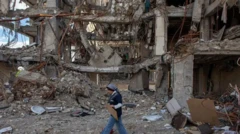 زنی با لباس آبی و شلوار جین در کنار یک ساختمان تخریب شده 