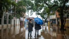 Mulheres em rua tomada por enchente em Porto Alegre