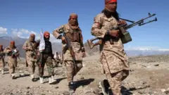 Afghan Taliban fighters and villagers attend a gathering as they celebrate the peace deal signed between US and Taliban in Laghman Province, Alingar district on March 2, 2020.
