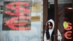 Москва шаҳридаги банк валюта айирбошлаш шохобчасида хорижий валюталар белгилари ва банк эшигидан чиқиб келаётган қора кўзойнакли қиз
