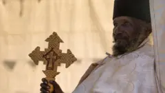 Priest with a cross in Entoto orthodox Maryam Church, Addis Ababa