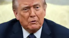 Ifoto ngufi igaragaza Perezida w'Amerika Donald Trump yambaye ikositimu y'ubururu, ishati y'umweru na karuvati y'ubururu irimo andi mabara mato, areba muri 'camera'.