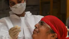 Un membre du personnel médical effectue un prélèvement nasal pour un test de dépistage rapide de l'antigène (Rapid Antigen Testing - RAT) dans un contexte d'augmentation des cas de coronavirus Covid-19, à Mumbai, le 19 avril 2021.