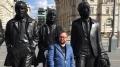 Allan in front of a (slightly larger than life) statue of the Beatles