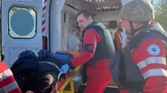 медики грузят раненого на носилках в машину скорой 