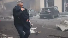 बच्चा बोकेर निस्किँदै एक पुरुष