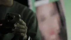 한 남성이 휴대폰으로 불법 성착취물을 보고 있는 장면