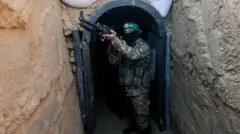 مسلح يقف داخل نفق