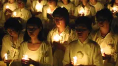 Members of the Falun Gong spiritual movement hold candles during a candlelight vigil July 19, 2001 in Washington, DC