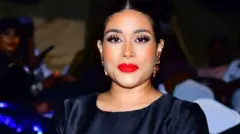 Aworan yii ṣafihan Adunni Adewale tawọn eeyan mọ si Adunni Ade. Obinrin pupa to wọ aṣọ dudu, o ko irun rẹ sẹyin, o lo yẹti si eti rẹ, o si tọ ete rẹ ni awọ pupa. Adunni n wo ọọkan ninu fọto naa