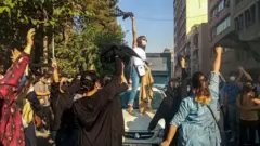 معترضان زن بدون حجاب اجباری در حال شعار دادن 
