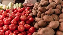 Imagine prim-plan cu roșii și cartofi expuse la o piață a fermierilor
