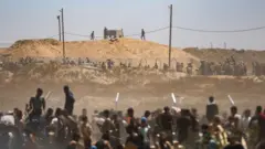 فلسطينيون يتلقون مساعدات من مجموعة مدعومة من الولايات المتحدة في معبر نتساريم بغزة - 29 مايو 2025