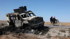 Yol kenarında yanmış bir tank.