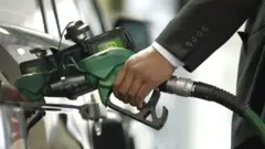 ነዳጅ ለመኪና የሚሞላ ሰው እጅ
