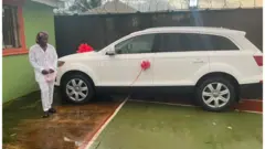 ኣብ ቅድሚ መኪና ደው ዝበለት ሰበይቲ