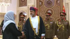 هيثم بن طارق سلطان عمان الجديد يسلم على سيدة ووراءه الحرس السلطاني العماني.