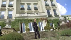 Boris Berezovsky vestido de preto, na frente de uma casa