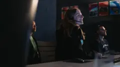 Pessoas no interior de um centro de comando espacial.