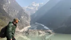 BBC国际部环境事务记者纳文·辛格·卡达（Navin Singh Khadka）在健行，其身后可看到有雾霾遮蔽了山脉