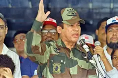 Manuel Noriega discursa em uniforme militar e cercado por pessoas no Panamá, em 1988.