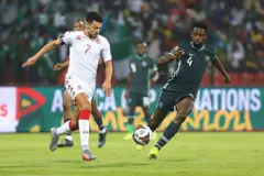 Tunisia's forward Youssef Msakni (L) fights for the ball with Nigeria's midfielder Wilfred Ndidi during the Africa Cup of Nations (CAN) 2021 round of 16 football match between Nigeria and Tunisia at Stade Roumde Adjia in Garoua on January 23, 2022.