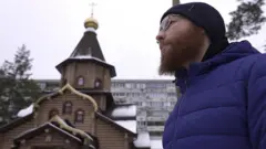 Священник Георгий Сухобокий на фоне церкви