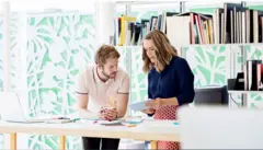 موظفان من جيل الألفية يستخدمان وسائل تكنولوجيا