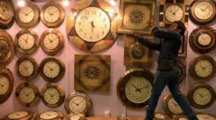 የግድግዳ ሰዓቶችን እየሰቀለ ያለ ሰው 