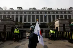 태극기를 들고 헌법재판소 앞을 지나는 한 남성