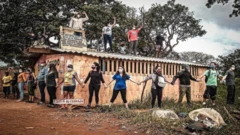 Pessoas fazendo um cordão humano para proteger imóvel ameaçado de despejo