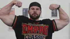 Joey Farrell mostrando os bíceps