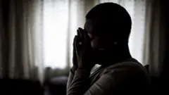 Woman wey cover her face.