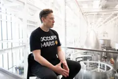 Elon Musk con uma camiseta que tem "Occupy Mars" escrita
