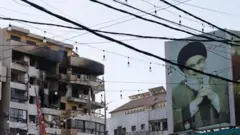 Поврежденное здание в Бейруте и портрет бывшего лидера "Хезболлы" Хасана Насраллы, который был убит в результате израильского авиаудара в 2024 году