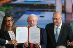 Lula, Janja e Geraldo Alckmin segurando documento com o veto assinado pelo presidente