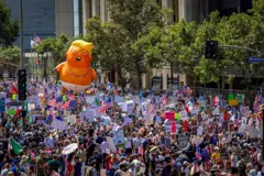 Un globo en la forma de una caricatura de Trump flota por encima de una multitudinaria protesta en Los Ágeles, California, 14 de junio de 2025