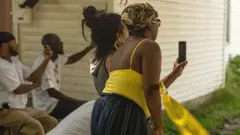 Onlookers film a police scene on their phones