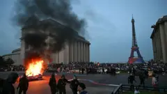 Підпалений автомобіль, коли вболівальники ПСЖ святкують перемогу своєї команди у фіналі Ліги чемпіонів УЄФА між Парі Сен-Жермен (ПСЖ) та ФК "Арсенал", що відбувся в Будапешті, на площі Трокадеро навпроти Ейфелевої вежі в Парижі 30 травня 2026 року.