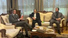 سمت چپ، رافائل گروسی، مدیرکل آژانس بین‌المللی انرژی اتمی در کنار او فرد وسطی عباس عراقچی وزیر خارجه ایران و در سمت راست یک مقام دیگر ایرانی نشسته اند.