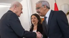 DEM parti vekili Mithat Sancar, Bahçeli'nin elini yakın bir mesafeden sıkıyor. Pervin Buldan arkada ikiliyi gülerek izliyor.